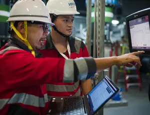 Deux hommes casqués échangent devant un écran 